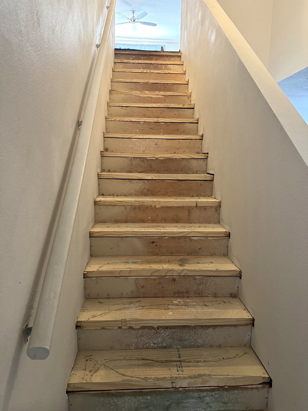 Staircase with bare plywood treads before
